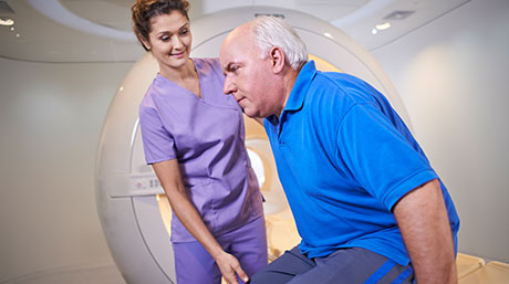 un'infermiera che parla con un uomo in una macchina per la scansione TC