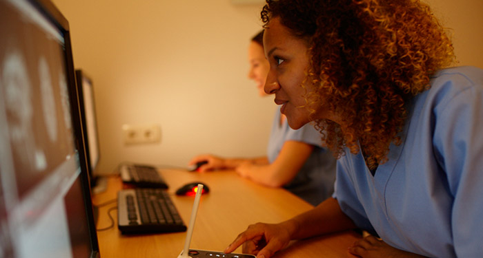 una donna seduta alla scrivania con un computer